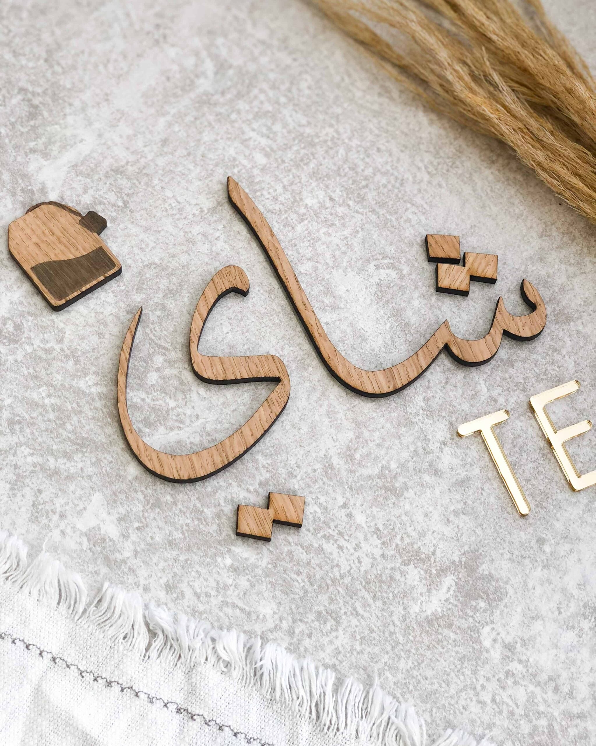 Dekorativt te-skilt med arabisk kalligrafi og teksten TE, fås i egefinér, valnødsfinér eller spejlakryl