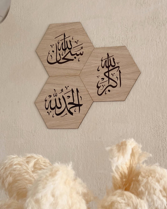 Tre dhikr rammer i egetræsfinér med arabisk kalligrafi på væg