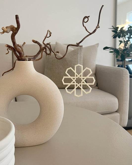 Geometrisk ophæng i beige som hængende dekoration ved vase i stuen