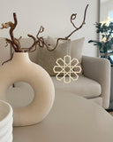 Geometrisk ophæng i beige som hængende dekoration ved vase i stuen