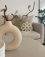 Geometrisk ophæng i beige som hængende dekoration ved vase i stuen