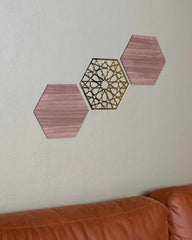 Tre hexagon vægpaneler i valnød med geometrisk gulddetalje