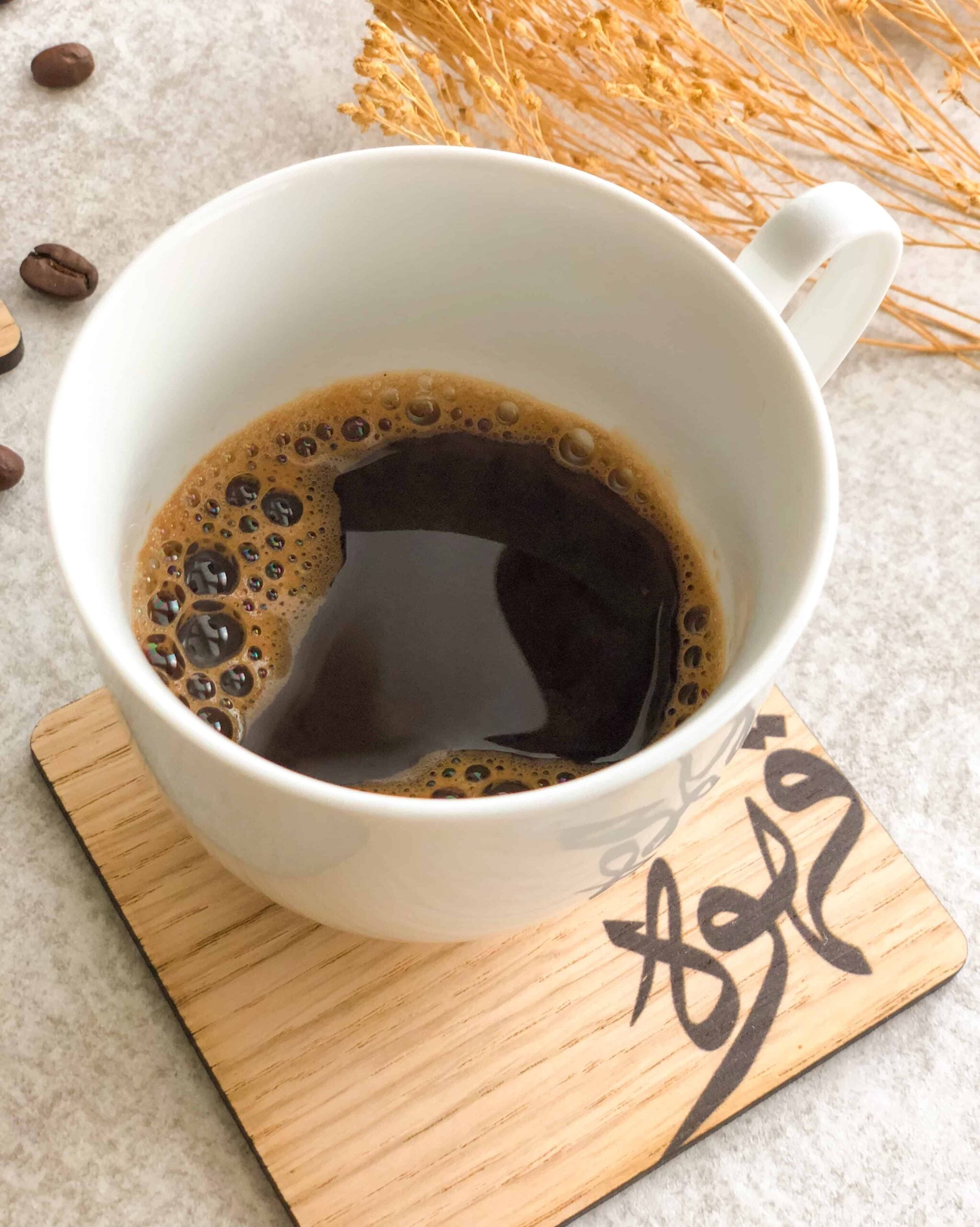 Kaffekop på bordskåner i valnødsfinér eller egefinér med dekorativt kaffedesign