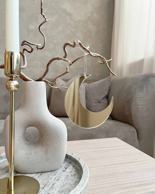 Minimalistisk måne i guld spejlakryl som hængende dekoration i stuen