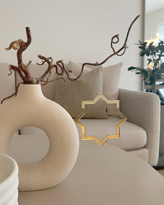 Minimalistisk stjerne i guld spejlakryl som hængende dekoration i stuen